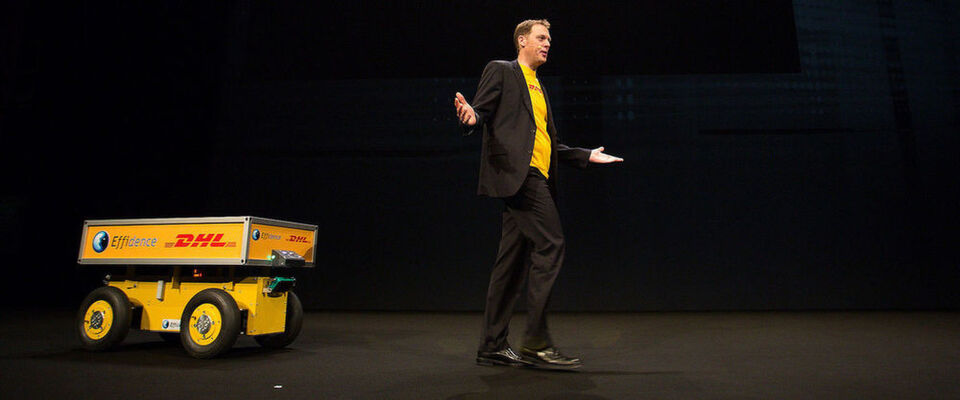 Dr. Markus Voss, DHL-CIO, mit dem Roboter-Rollwagen "Effibot" auf der Bühne des Fujitsu Forum in München Dr. Markus Voss, DHL-CIO, mit dem Roboter-Rollwagen "Effibot" auf der Bühne des Fujitsu Forum in München