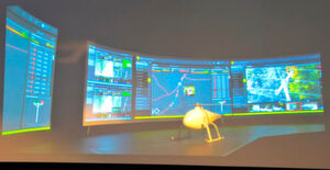 Drohnen wie diese fliegen beispielsweise Strommasten an, um mithilfe verschiedener Aufnahmegeräte und analytischer Algorithmen im Hintergrund Schäden am Stromnetz schnell zu detektieren. Im Hintergrund sind Überwachsungs-Screens zu erkennen. Drohnen wie diese fliegen beispielsweise Strommasten an, um mithilfe verschiedener Aufnahmegeräte und analytischer Algorithmen im Hintergrund Schäden am Stromnetz schnell zu detektieren. Im Hintergrund sind Überwachsungs-Screens zu erkennen.