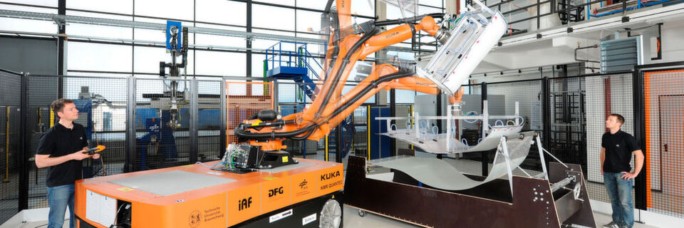 Für die Erforschung mobiler und automatisierter Herstellung großer Bauteile aus faserverstärkten Kunststoffen stehen der TU Braunschweig zwei mobile, batteriebetriebene Industrieroboter zur Verfügung, die eigenständig große Leichtbaustrukturen produzieren können. Die mobilen Produktionsroboter „KMR Quantec-TUBS“ wurden im Rahmen der Kooperation „DLR@UNI“ vom Institut für Adaptronik und Funktionsintegration der Technischen Universität Braunschweig und vom Institut für Faserverbundleichtbau und Adaptronik des Deutschen Zentrums für Luft- und Raumfahrt in Braunschweig konzipiert. Für die Erforschung mobiler und automatisierter Herstellung großer Bauteile aus faserverstärkten Kunststoffen stehen der TU Braunschweig zwei mobile, batteriebetriebene Industrieroboter zur Verfügung, die eigenständig große Leichtbaustrukturen produzieren können. Die mobilen Produktionsroboter „KMR Quantec-TUBS“ wurden im Rahmen der Kooperation „DLR@UNI“ vom Institut für Adaptronik und Funktionsintegration der Technischen Universität Braunschweig und vom Institut für Faserverbundleichtbau und Adaptronik des Deutschen Zentrums für Luft- und Raumfahrt in Braunschweig konzipiert.