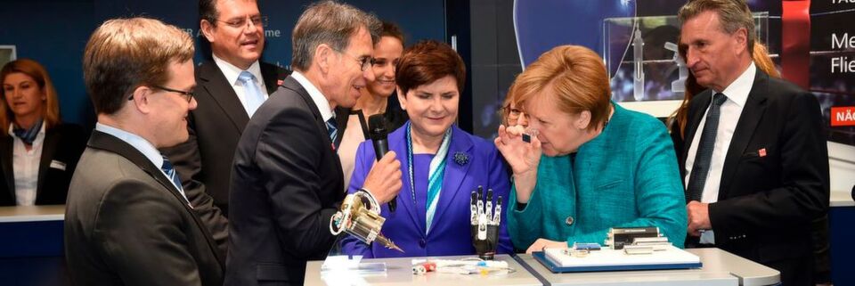 Da muss sie schon ganz genau hinsehen. Die Bundeskanzlerin schaut sich am Stand von Faulhaber auf der Hannover Messe 2017 einen Mikromotor mit nur 1,9 mm Durchmesser an. Da muss sie schon ganz genau hinsehen. Die Bundeskanzlerin schaut sich am Stand von Faulhaber auf der Hannover Messe 2017 einen Mikromotor mit nur 1,9 mm Durchmesser an.