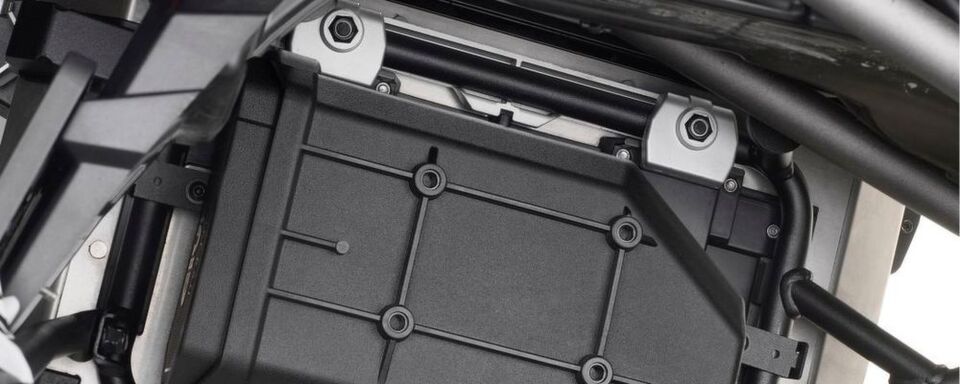 Durch ein spezielles Kit kann die Tool Box auch auf dem Seitenkoffer-Träger montiert werden. Die Kompatibilität des eigenen Fahrzeugs kann auf der Website überprüft werden. Durch ein spezielles Kit kann die Tool Box auch auf dem Seitenkoffer-Träger montiert werden. Die Kompatibilität des eigenen Fahrzeugs kann auf der Website überprüft werden.