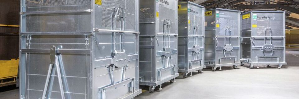 Für die Beförderung von Paketen und Postsendungen bei Deutsche Post DHL sind die Rollcontainer von Wanzl im Hand- und Schleppzug koppelbar. Für die Beförderung von Paketen und Postsendungen bei Deutsche Post DHL sind die Rollcontainer von Wanzl im Hand- und Schleppzug koppelbar.