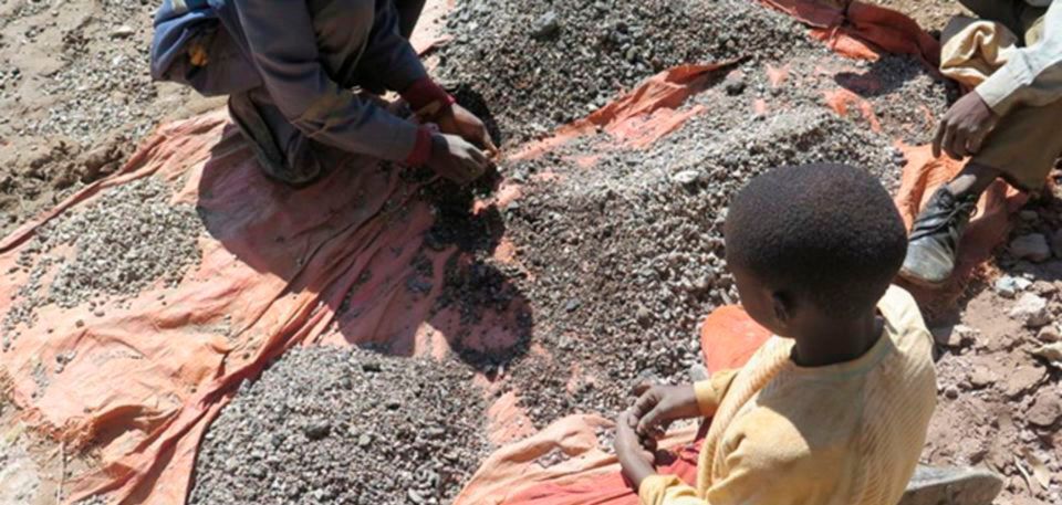 Drei Kinder sortieren Steine, die Kobalt enthalten an den Ufern des Malo-Sees (Kongo). Drei Kinder sortieren Steine, die Kobalt enthalten an den Ufern des Malo-Sees (Kongo).