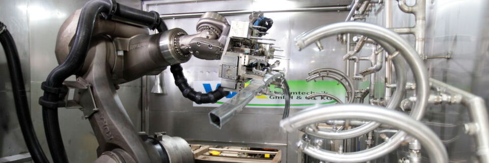 Die Umgebung, in der der Kuka-Roboter seine Tätigkeit ausführt, ist für Industrieroboter normalerweise nicht geeignet, denn der Roboter ist großen Wassermengen ausgesetzt, denen zu 3% noch alkalische Reiniger beigesetzt sind. Daneben herrschen in der Wasch-zelle Temperaturen von 60°C , was zu erheblichem Wasserdampf führt. Damit der Roboter durch die äußeren Einflüsse nicht zu Schaden kommt, wurden besondere Schutzvorrichtungen getroffen. Die Umgebung, in der der Kuka-Roboter seine Tätigkeit ausführt, ist für Industrieroboter normalerweise nicht geeignet, denn der Roboter ist großen Wassermengen ausgesetzt, denen zu 3% noch alkalische Reiniger beigesetzt sind. Daneben herrschen in der Wasch-zelle Temperaturen von 60°C , was zu erheblichem Wasserdampf führt. Damit der Roboter durch die äußeren Einflüsse nicht zu Schaden kommt, wurden besondere Schutzvorrichtungen getroffen.