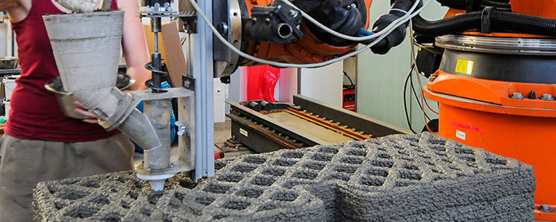 An der Versuchsanlage für additive Fertigung wird durch Extrusion von Holzleichtbeton ein multifunktionales Wandelement hergestellt. An der Versuchsanlage für additive Fertigung wird durch Extrusion von Holzleichtbeton ein multifunktionales Wandelement hergestellt.