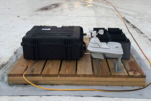 Der Testaufbau, mit dem Forscher im Verlauf mehrerer Monate ihr Prinzip des neuen Energiegewinnungskonzeptes auf dem Dach eines MIT-Gebäudes unter Beweis stellten: Das Testgerät selbst ist der schwarze Kasten auf der rechten Seite, der hinter einem Wetterüberwachungssystem (weiß) platziert ist. Einer Reihe von Testgeräten (größeres schwarzes Gehäuse links) überwacht die Geräteleistung. Der Testaufbau, mit dem Forscher im Verlauf mehrerer Monate ihr Prinzip des neuen Energiegewinnungskonzeptes auf dem Dach eines MIT-Gebäudes unter Beweis stellten: Das Testgerät selbst ist der schwarze Kasten auf der rechten Seite, der hinter einem Wetterüberwachungssystem (weiß) platziert ist. Einer Reihe von Testgeräten (größeres schwarzes Gehäuse links) überwacht die Geräteleistung.