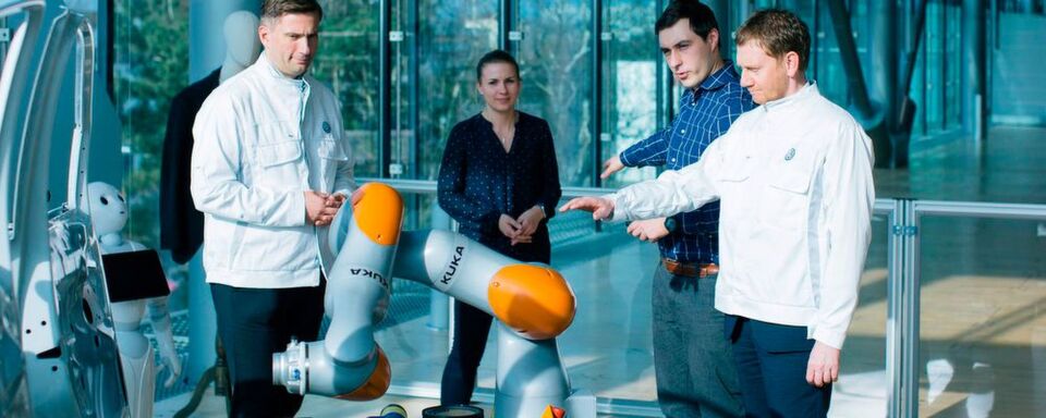Sachsens Ministerpräsident Michael Kretschmer (rechts) probiert in der Gläsernen Manufaktur von Volkswagen in Dresden die neue Sensorjacke von Wandelbots aus. Sachsens Ministerpräsident Michael Kretschmer (rechts) probiert in der Gläsernen Manufaktur von Volkswagen in Dresden die neue Sensorjacke von Wandelbots aus.