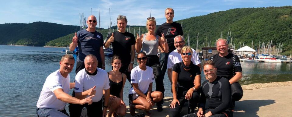 Gruppe 6 mit Tourguide Stephan Maderner und den beiden Eventmanagerinnen Uschi und Elena mit Badeschlappen am Rursee. Gruppe 6 mit Tourguide Stephan Maderner und den beiden Eventmanagerinnen Uschi und Elena mit Badeschlappen am Rursee.