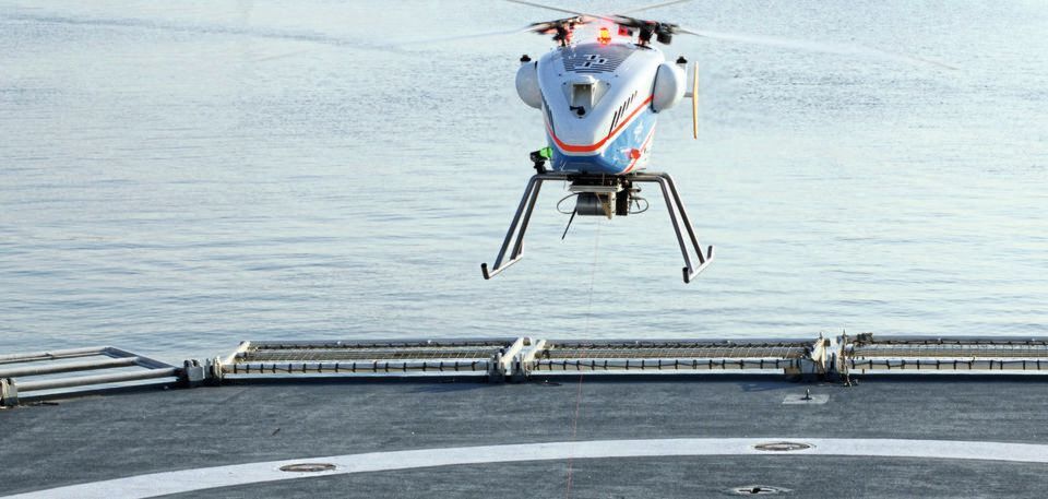 Der DLR hat im Rahmen eines zweijährigen Projekts erfolgreich Start und Landung unbemannter Helikopter für die Überwachung der globalen Seewege getestet. Für die Landung wurde das Seil über die Seilwinde von der SuperARTIS-Drohne zum Schiffsdeck abgelassen und dort mittels Magneten fixiert. Der DLR hat im Rahmen eines zweijährigen Projekts erfolgreich Start und Landung unbemannter Helikopter für die Überwachung der globalen Seewege getestet. Für die Landung wurde das Seil über die Seilwinde von der SuperARTIS-Drohne zum Schiffsdeck abgelassen und dort mittels Magneten fixiert.