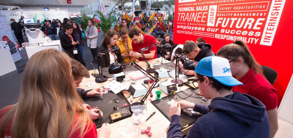 Besucher des Würth-Elektronik-eiSos-Messestandes hatten die Möglichkeit, ihren eigenen leuchtenden Fidget-Spinner mit Produkten des Unternehmens an Lötstationen zu bauen. Besucher des Würth-Elektronik-eiSos-Messestandes hatten die Möglichkeit, ihren eigenen leuchtenden Fidget-Spinner mit Produkten des Unternehmens an Lötstationen zu bauen.