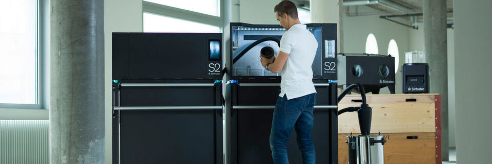 Für das selektive Lasersintern hat Sintratec auf der Formnext 2018 einen Aufbau mit Drucker, Pulverhandlingstation, Transportfahrzeug und Nachbearbeitungselementen vorgestellt. Für das selektive Lasersintern hat Sintratec auf der Formnext 2018 einen Aufbau mit Drucker, Pulverhandlingstation, Transportfahrzeug und Nachbearbeitungselementen vorgestellt.
