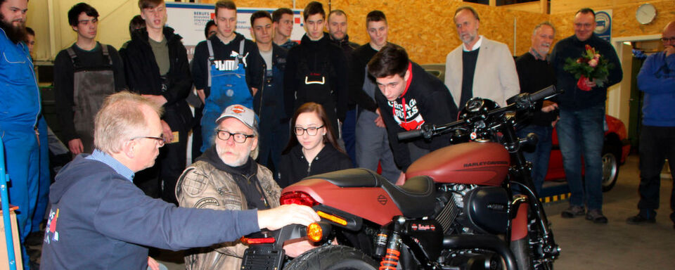 Die Harley-Davidson Street Rod mit (v. li.) Ferdinand Schütt, Björn Andersson, Azubis Celine Schneidereit und Nicklas Blome. Dahinter im weißen Jackett: Matthias Links. Die Harley-Davidson Street Rod mit (v. li.) Ferdinand Schütt, Björn Andersson, Azubis Celine Schneidereit und Nicklas Blome. Dahinter im weißen Jackett: Matthias Links.