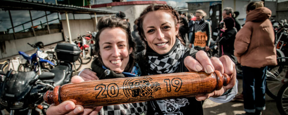 Hayley Bell (re.) und der handgeschnitzte Staffelstab von WRWR – Symbol für alle Powerfrauen in der Motorradszene. Hayley Bell (re.) und der handgeschnitzte Staffelstab von WRWR – Symbol für alle Powerfrauen in der Motorradszene.