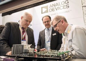 Patrick Wilson (Direktor des US-Büros für Geschäftsbeziehungen, links) und Josef Lechner (Senior Sales Direktor EMEA bei Analog Devices, Mitte) lassen sich ein integriertes System des Elektronikunternehmens demonstrieren. In einem Round-Table-Gespräch setzte sich Lechner für einen Abbau bestehender Handelsregularien zwischen der EU und den USA ein. Patrick Wilson (Direktor des US-Büros für Geschäftsbeziehungen, links) und Josef Lechner (Senior Sales Direktor EMEA bei Analog Devices, Mitte) lassen sich ein integriertes System des Elektronikunternehmens demonstrieren. In einem Round-Table-Gespräch setzte sich Lechner für einen Abbau bestehender Handelsregularien zwischen der EU und den USA ein.