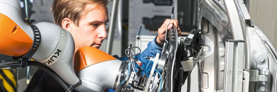 Sinnvolle Arbeitsteilung: Der Roboter trägt die Last und reicht an, der Werker unterstützt ihn beim passgenauen Einsetzen eines Bauteils. Sinnvolle Arbeitsteilung: Der Roboter trägt die Last und reicht an, der Werker unterstützt ihn beim passgenauen Einsetzen eines Bauteils.