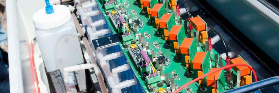 Der Demonstrator des Speichers soll seinen Aufbau verdeutlichen. Die blauen Kästen sind die Zellen, im Gefäß links befindet sich das Elektrolyt, das durch die Schläuche weitergeleitet wird. Der Demonstrator des Speichers soll seinen Aufbau verdeutlichen. Die blauen Kästen sind die Zellen, im Gefäß links befindet sich das Elektrolyt, das durch die Schläuche weitergeleitet wird.
