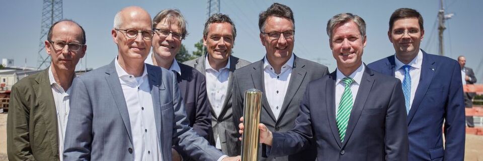 Beim versenken der Zeitkapsel (v.l.): Stefan Tebroke, Architekt von BHBVT, Dr. Peter Tschentscher, erster Bürgermeister der Hansestadt Hamburg, Prof. Dr. Hendrik Brinksma, Präsident der TUHH, Christian Langfeld, Leiter Abteilung Bau der Fraunhofer-Gesellschaft, Prof. Dr.-Ing. Uwe Clausen, Leiter Fraunhofer-IML, Prof. Dr. Ing. Carlos Jahn, Leiter Fraunhofer-CML sowie Ole John, Baubeauftragter des Fraunhofer-CML. Beim versenken der Zeitkapsel (v.l.): Stefan Tebroke, Architekt von BHBVT, Dr. Peter Tschentscher, erster Bürgermeister der Hansestadt Hamburg, Prof. Dr. Hendrik Brinksma, Präsident der TUHH, Christian Langfeld, Leiter Abteilung Bau der Fraunhofer-Gesellschaft, Prof. Dr.-Ing. Uwe Clausen, Leiter Fraunhofer-IML, Prof. Dr. Ing. Carlos Jahn, Leiter Fraunhofer-CML sowie Ole John, Baubeauftragter des Fraunhofer-CML.