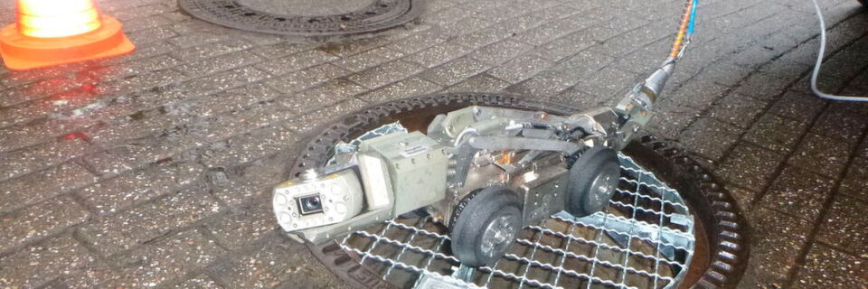 Ein Kanalinspektionsfahrzeug, gesteuert per Kamera, zog das Kabel in die Rohre ein Ein Kanalinspektionsfahrzeug, gesteuert per Kamera, zog das Kabel in die Rohre ein