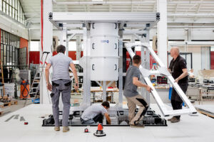 Italien, Mailand: Mitarbeiter des Gehäuse- und Installationsdesigners Goppion bauen den Rahmen für einen Quantencomputer vom Typ „IBM Q System One“ auf und bereiten diesen für Tests vor. Das Gehäuse beinhaltet verschiedene Komponenten des Systems wie zum Beispiel Kryostat, Quantenprozessor und Steuerelektronik. Italien, Mailand: Mitarbeiter des Gehäuse- und Installationsdesigners Goppion bauen den Rahmen für einen Quantencomputer vom Typ „IBM Q System One“ auf und bereiten diesen für Tests vor. Das Gehäuse beinhaltet verschiedene Komponenten des Systems wie zum Beispiel Kryostat, Quantenprozessor und Steuerelektronik.