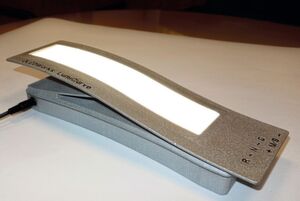 Biegbare OLED: Sie wurde in ein entsprechend gestaltetes Gehäuse eingeschoben und erhält dadurch ihre Krümmungsform. Das gesamte Trägerelement wurde im 3D-Druckverfahren hergestellt. Deshalb sind die Oberflächen nicht so perfekt wie bei einem polierten Fräs- oder einem gespritzten Kunststoffteil. Biegbare OLED: Sie wurde in ein entsprechend gestaltetes Gehäuse eingeschoben und erhält dadurch ihre Krümmungsform. Das gesamte Trägerelement wurde im 3D-Druckverfahren hergestellt. Deshalb sind die Oberflächen nicht so perfekt wie bei einem polierten Fräs- oder einem gespritzten Kunststoffteil.