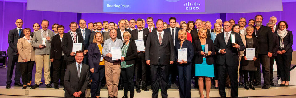 Die Gewinner des eGovernment-Wettbewerbs 2019 zusammen mit dem Schirmherr n des Wettbewerbs Helge Braun auf der großen Bühne des bcc in Berlin Die Gewinner des eGovernment-Wettbewerbs 2019 zusammen mit dem Schirmherr n des Wettbewerbs Helge Braun auf der großen Bühne des bcc in Berlin