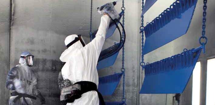 Semi finished parts are being spray painted in a factory. Semi finished parts are being spray painted in a factory.