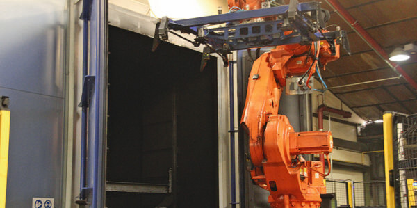 Bild 1: In der Strahlanlage befreit RHI seine stählernen Umlaufpaletten von Teerrückständen, die Handhabung übernimmt ein Roboter. Bild 1: In der Strahlanlage befreit RHI seine stählernen Umlaufpaletten von Teerrückständen, die Handhabung übernimmt ein Roboter.