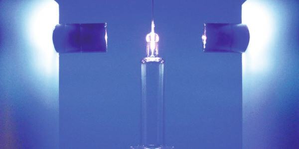 Eine Metallnadel wird in eine Glasspritze verklebt: Der Klebstoff wird mit zwei LED-Köpfen ausgehärtet. Eine Metallnadel wird in eine Glasspritze verklebt: Der Klebstoff wird mit zwei LED-Köpfen ausgehärtet.
