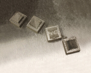 One of two illustrations of the effect of part orientation. The part below was produced by three different additive manufacturing suppliers. The components they delivered were all different, because each supplier chose to orient the part in a different way. At right, delicate features are produced with differing levels of success depending on their orientation with respect to the machine’s moving blade. One of two illustrations of the effect of part orientation. The part below was produced by three different additive manufacturing suppliers. The components they delivered were all different, because each supplier chose to orient the part in a different way. At right, delicate features are produced with differing levels of success depending on their orientation with respect to the machine’s moving blade.