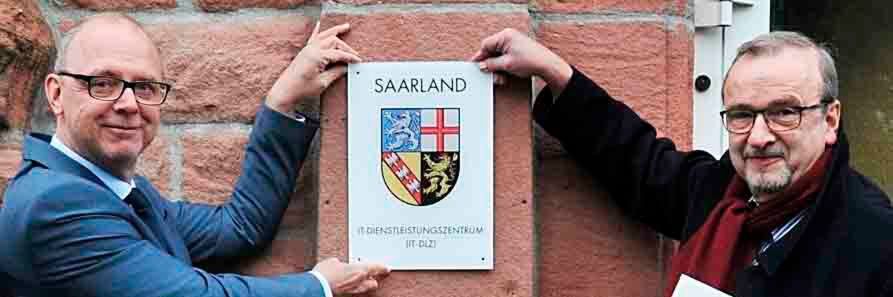 Auch im digitalen Zeitalter braucht man noch ein Türschild. Finanzstaatssekretär Dr. Axel Spies (r.) überreichte es Direktor Dr. Hanno Thewes zum offiziellen Start des IT-DLZ Auch im digitalen Zeitalter braucht man noch ein Türschild. Finanzstaatssekretär Dr. Axel Spies (r.) überreichte es Direktor Dr. Hanno Thewes zum offiziellen Start des IT-DLZ